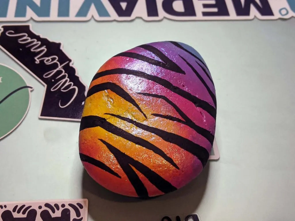 multi-color painted rock with zebra stripes and glitter