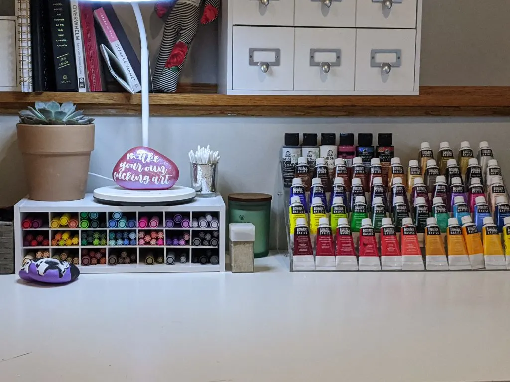 paint pens and paint tubes organized on a desktop